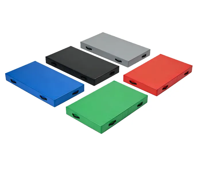Set of five thick crash mats in blue, black, gray, red and green with black side handles for gymnastics training